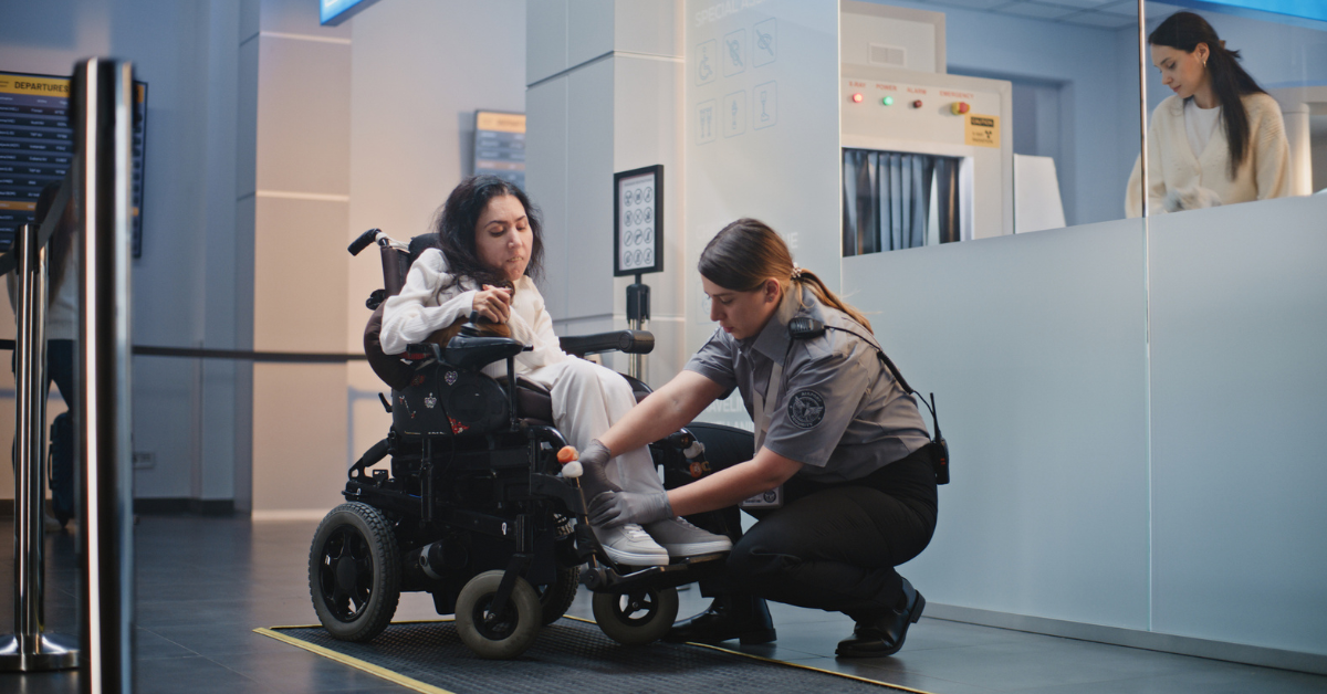 Woman in power wheelchair at the airport getting a security check