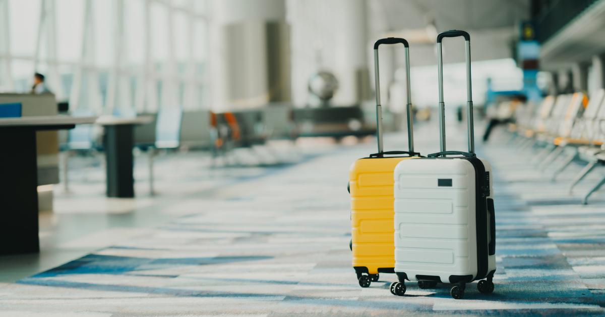 Image of two suitcases in an empty airport hall