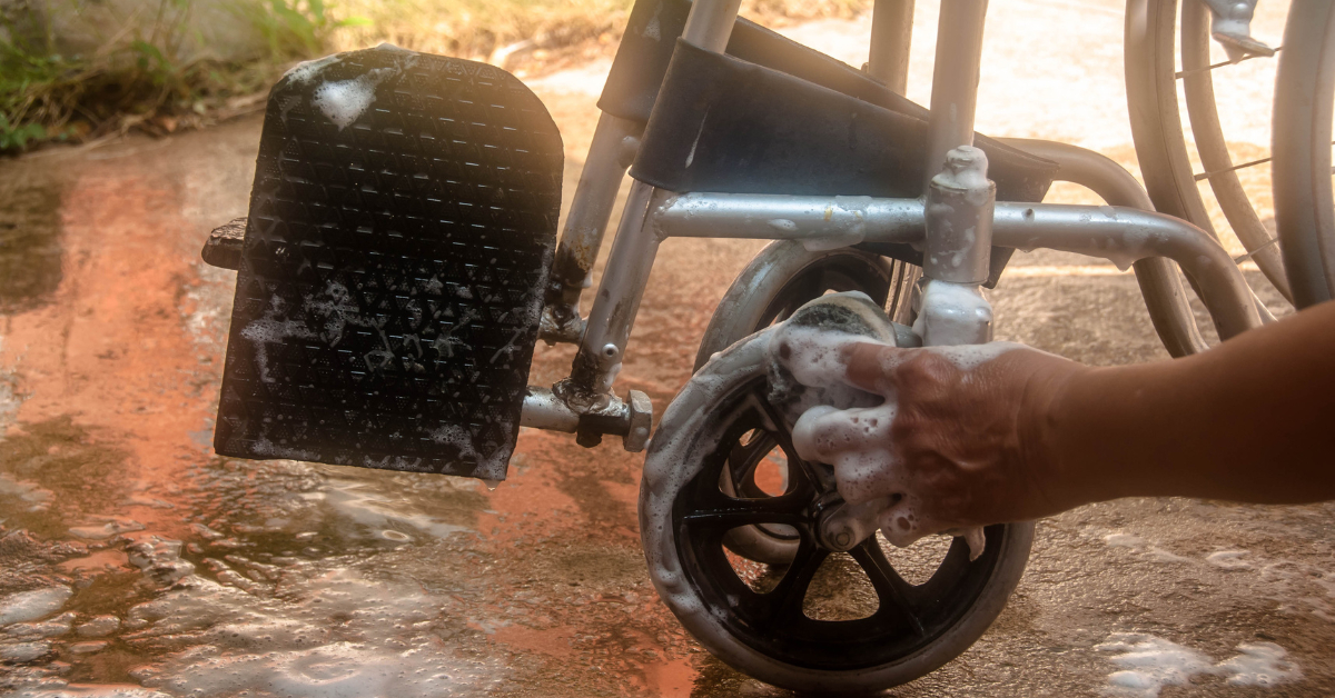 Person cleaning wheelchair with soap and water