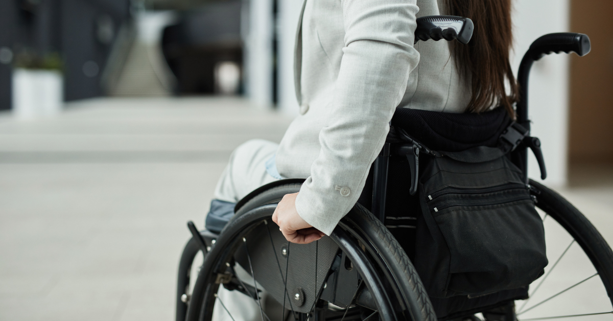 Woman in wheelchair with back facing camera from elbow down