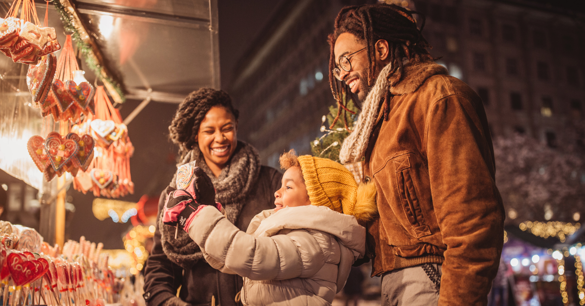 Mom and dad with their daughter at a Christmas market