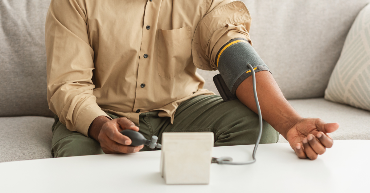 Man sitting on the couch and checking his blood pressure