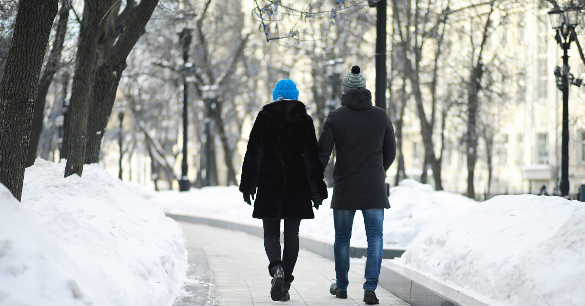 Couple holding hands and walking on path in the winter